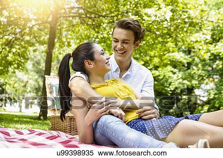Young couple snuggling together on picnic blanket View Large Photo Image Stock Photography - Young couple snuggling together on picnic blanket. Fotosearch