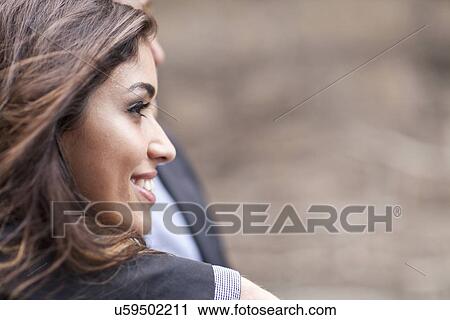 "Young couple standing together, outdoors, looking away, smiling" View Large Photo Image Stock Image - "Young couple standing together, outdoors, looking away, smiling". Fotosearch