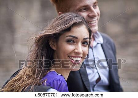 "Young couple standing together, outdoors, looking away, smiling" View Large Photo Image Stock Image - "Young couple standing together, outdoors, looking away, smiling". Fotosearch