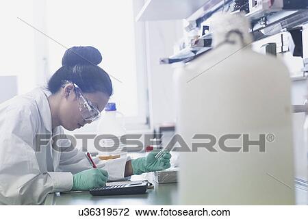 Young female scientist making research notes on lab workbench View Large Photo Image Stock Image - Young female scientist making research notes on lab workbench. Fotosearch