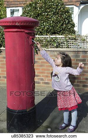 Stock Image - "Young girl at post box, reaching up to post letter". Fotosearch