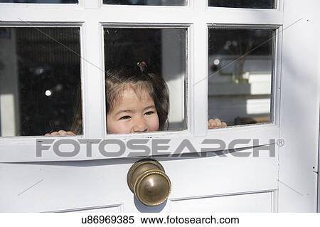 Stock Photography - Young girl looking out of window. Fotosearch