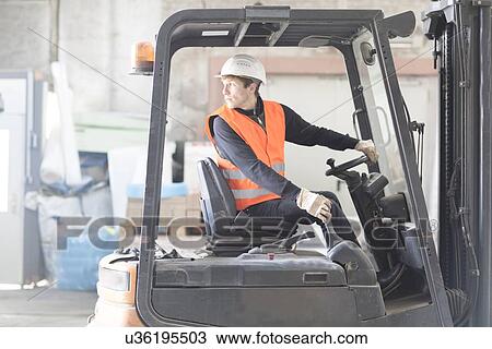 Young male warehouse worker reversing forklift truck in warehouse View Large Photo Image Stock Image - Young male warehouse worker reversing forklift truck in warehouse. Fotosearch