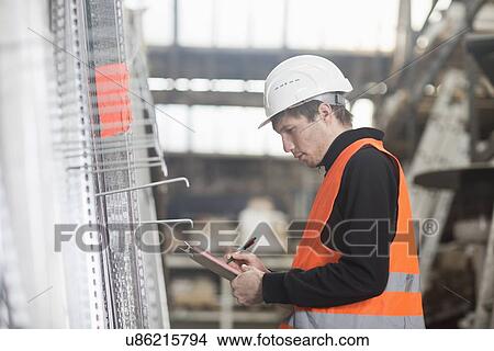Young male warehouse worker stock taking with clipboard in warehouse View Large Photo Image Picture - Young male warehouse worker stock taking with clipboard in warehouse. Fotosearch