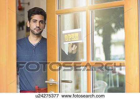 Young waiter opening cafe View Large Photo Image Stock Photo - Young waiter opening cafe. Fotosearch
