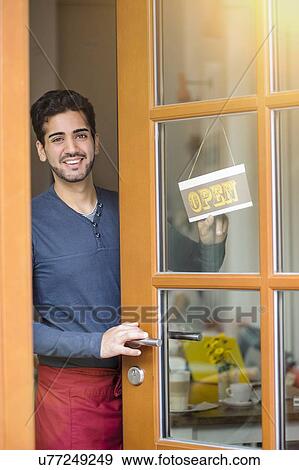 Young waiter opening cafe View Large Photo Image Stock Photo - Young waiter opening cafe. Fotosearch