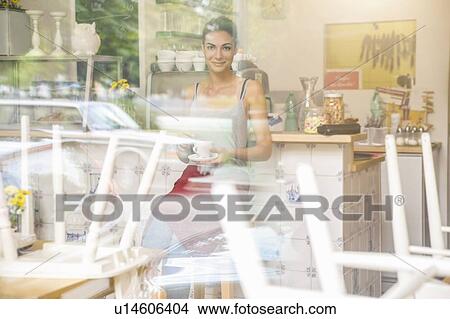 "Young waitress sitting in cafe, view through window" View Large Photo Image Picture - "Young waitress sitting in cafe, view through window". Fotosearch