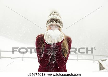 Young woman blowing handful of powder snow View Large Photo Image Stock Photo - Young woman blowing handful of powder snow. Fotosearch