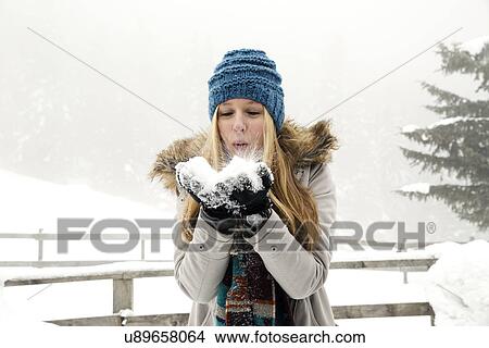 Young woman blowing handful of snow View Large Photo Image Picture - Young woman blowing handful of snow. Fotosearch