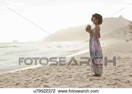 "Young woman drinking coconut milk on beach, Rio De Janeiro, Brazil" View Large Photo Image Stock Image - "Young woman drinking coconut milk on beach, Rio De Janeiro, Brazil". Fotosearch