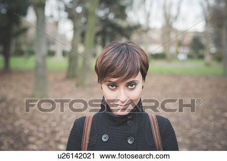 Stock Image - Young woman in park. Fotosearch