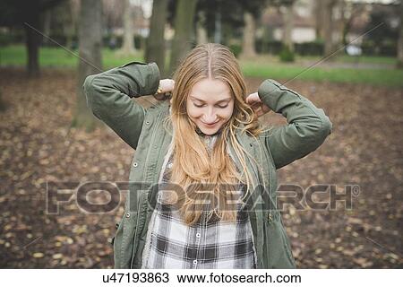 Stock Image - Young woman in park. Fotosearch