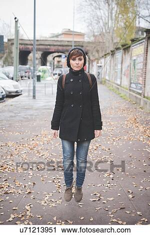 Stock Image - Young woman jumping on street. Fotosearch
