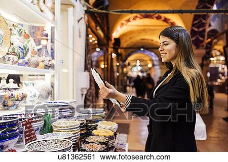 "Young woman looking at crockery on market stall, Istanbul, Turkey" View Large Photo Image Stock Image - "Young woman looking at crockery on market stall, Istanbul, Turkey". Fotosearch
