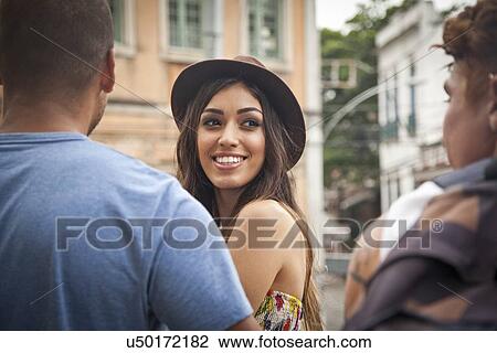 "Young woman looking over shoulder at friends, smiling" View Large Photo Image Stock Image - "Young woman looking over shoulder at friends, smiling". Fotosearch