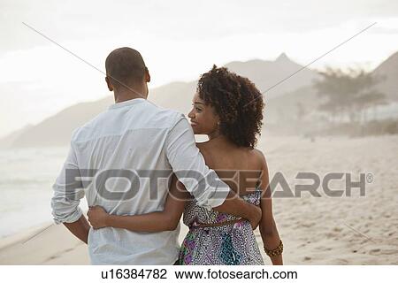 "Young woman looking over shoulder whilst strolling with boyfriend on beach, Rio De Janeiro, Brazil" View Large Photo Image Stock Image - "Young woman looking over shoulder whilst strolling with boyfriend on beach, Rio De Janeiro, Brazil". Fotosearch