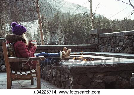 "Young woman sitting on bench with fire pit, Girdwood, Anchorage, Alaska" View Large Photo Image Picture - "Young woman sitting on bench with fire pit, Girdwood, Anchorage, Alaska". Fotosearch