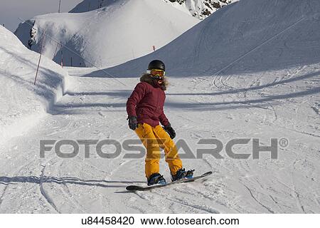 Stock Image - "Young woman snowboarding, Girdwood, Anchorage, Alaska". Fotosearch
