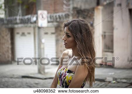 "Young woman standing in street, looking away" View Large Photo Image Stock Image - "Young woman standing in street, looking away". Fotosearch