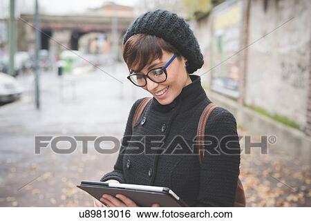 Young woman using digital tablet on street View Large Photo Image Stock Photograph - Young woman using digital tablet on street. Fotosearch