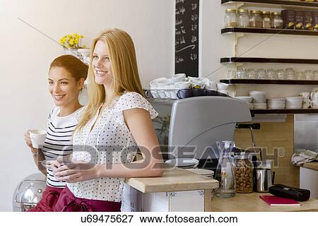 Young women working in cafe taking a break together View Large Photo Image Stock Photo - Young women working in cafe taking a break together. Fotosearch