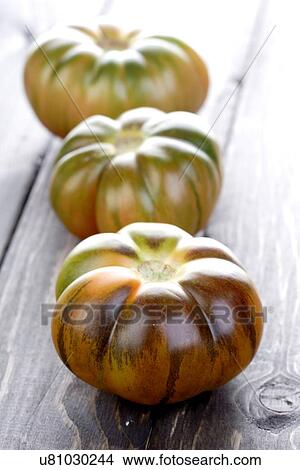 Picture - Black tomatoes on wooden table. Fotosearch