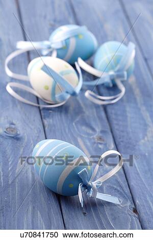 Stock Image - Blue and pink easter eggs on blue background. Fotosearch