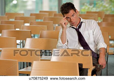 Stock Photo - bored Businessman sitting at conference room. Fotosearch