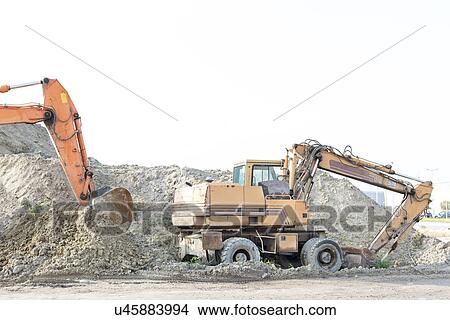 Picture - Bulldozers on construction site against clear sky. Fotosearch