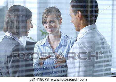 Stock Photo - Business people conversing in office. Fotosearch