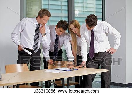 Business team looking at document in office View Large Photo Image Stock Photograph - Business team looking at document in office. Fotosearch
