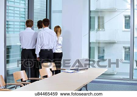 Stock Photo - Business team looking through window at office. Fotosearch
