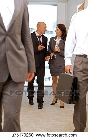 Business team walking thru corridor and talking View Large Photo Image Stock Image - Business team walking thru corridor and talking. Fotosearch