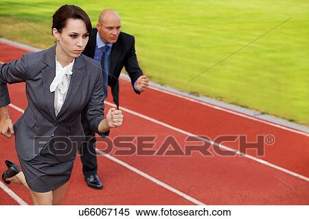 Stock Photography - Businessman and woman on running on race track. Fotosearch