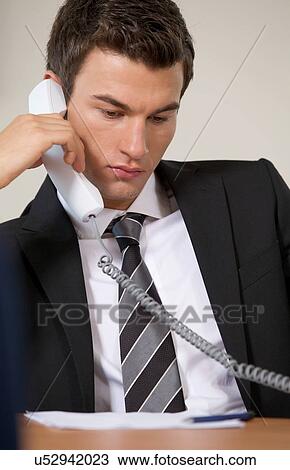 Businessman conversing on landline phone View Large Photo Image Stock Image - Businessman conversing on landline phone. Fotosearch