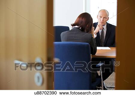 Stock Image - Businessman in discussion with businesswoman. Fotosearch