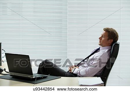 Businessman relaxing on chair with laptop on desk View Large Photo Image Picture - Businessman relaxing on chair with laptop on desk. Fotosearch
