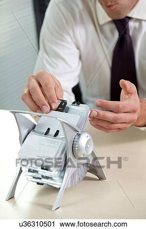 Businessman searching business card from stand View Large Photo Image Stock Image - Businessman searching business card from stand. Fotosearch