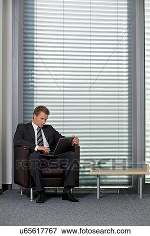 Stock Photo - Businessman using laptop in office. Fotosearch