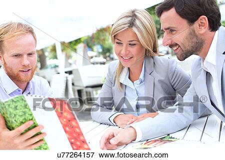 Businesspeople deciding menu at sidewalk cafe View Large Photo Image Stock Photo - Businesspeople deciding menu at sidewalk cafe. Fotosearch