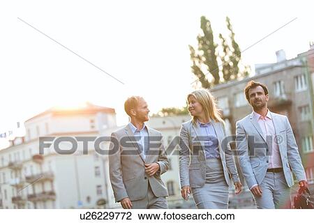 Businesspeople walking in city on sunny day View Large Photo Image Stock Image - Businesspeople walking in city on sunny day. Fotosearch