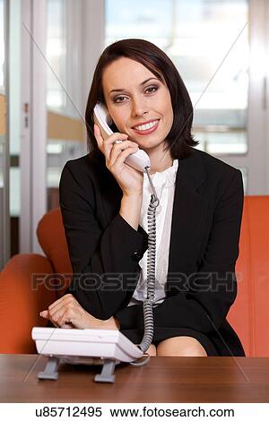 Businesswoman conversing on landline phone, portrait View Large Photo Image Stock Photography - Businesswoman conversing on landline phone, portrait. Fotosearch