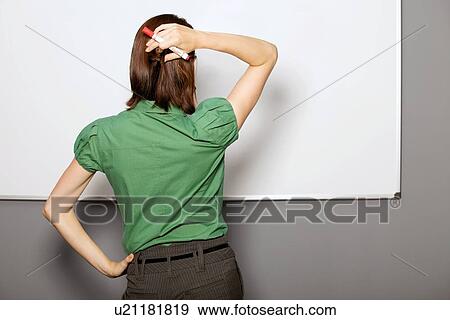 Stock Photo - Businesswoman standing in front of whiteboard in office. Fotosearch