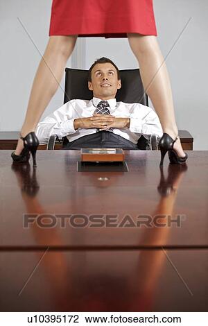 Businesswoman standing on table in front of businessman at office View Large Photo Image Stock Image - Businesswoman standing on table in front of businessman at office. Fotosearch