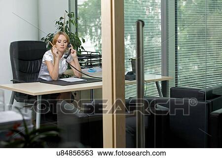 Businesswoman using phone at office View Large Photo Image Stock Image - Businesswoman using phone at office. Fotosearch