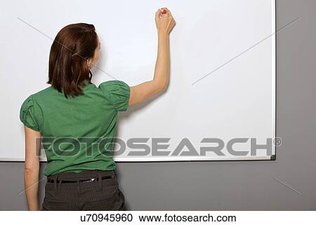 Businesswoman writing on whiteboard in office View Large Photo Image Stock Image - Businesswoman writing on whiteboard in office. Fotosearch