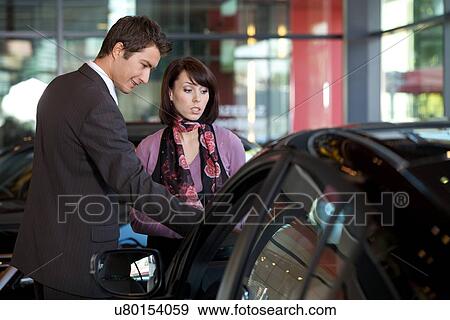 Car salesman explaining car features to customer View Large Photo Image Stock Photo - Car salesman explaining car features to customer. Fotosearch