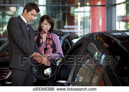Car salesman explaining car features to customer View Large Photo Image Stock Photo - Car salesman explaining car features to customer. Fotosearch