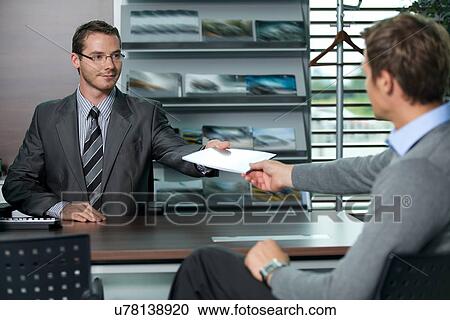 Car salesperson giving catalog to businessman View Large Photo Image Stock Image - Car salesperson giving catalog to businessman. Fotosearch