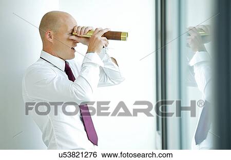 Stock Photograph - caucasian businessman spying using telescope thru office window. Fotosearch
